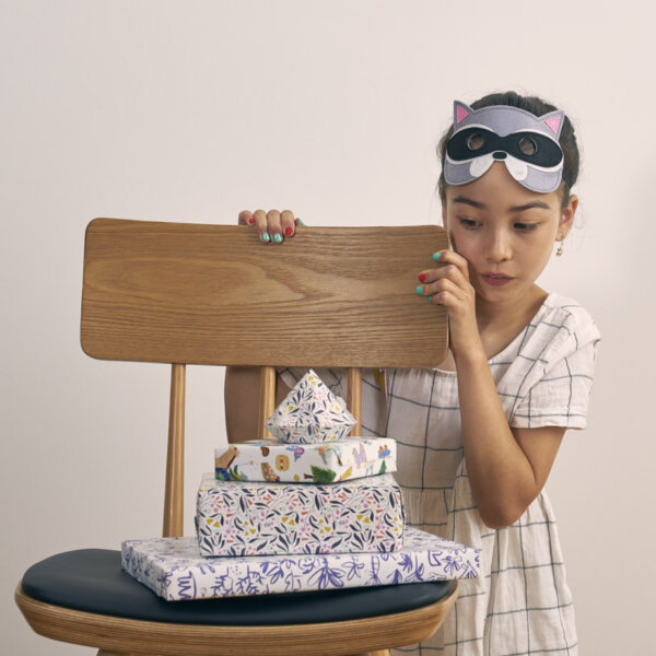 Home Impression Originale petite fille devant chaise remplie de cadeaux
