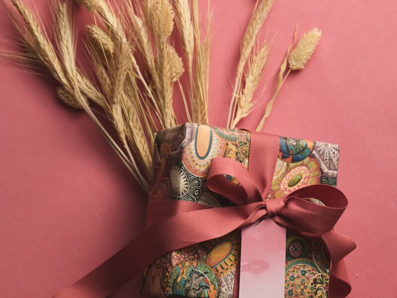 ORIGINALE gift and ribbon with wheat bouquet on indian red background