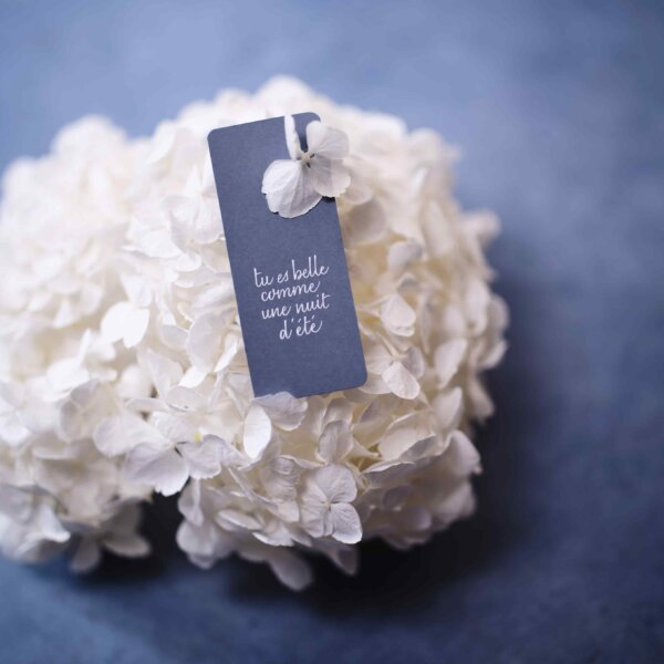 Calligraphic gift tag on a white bouquet of hydrangea on blue grey background by Impression Originale